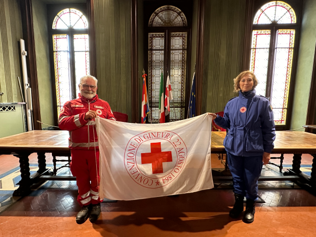 Torri illuminate di rosso e bandiera esposta per la Giornata mondiale della Croce Rossa