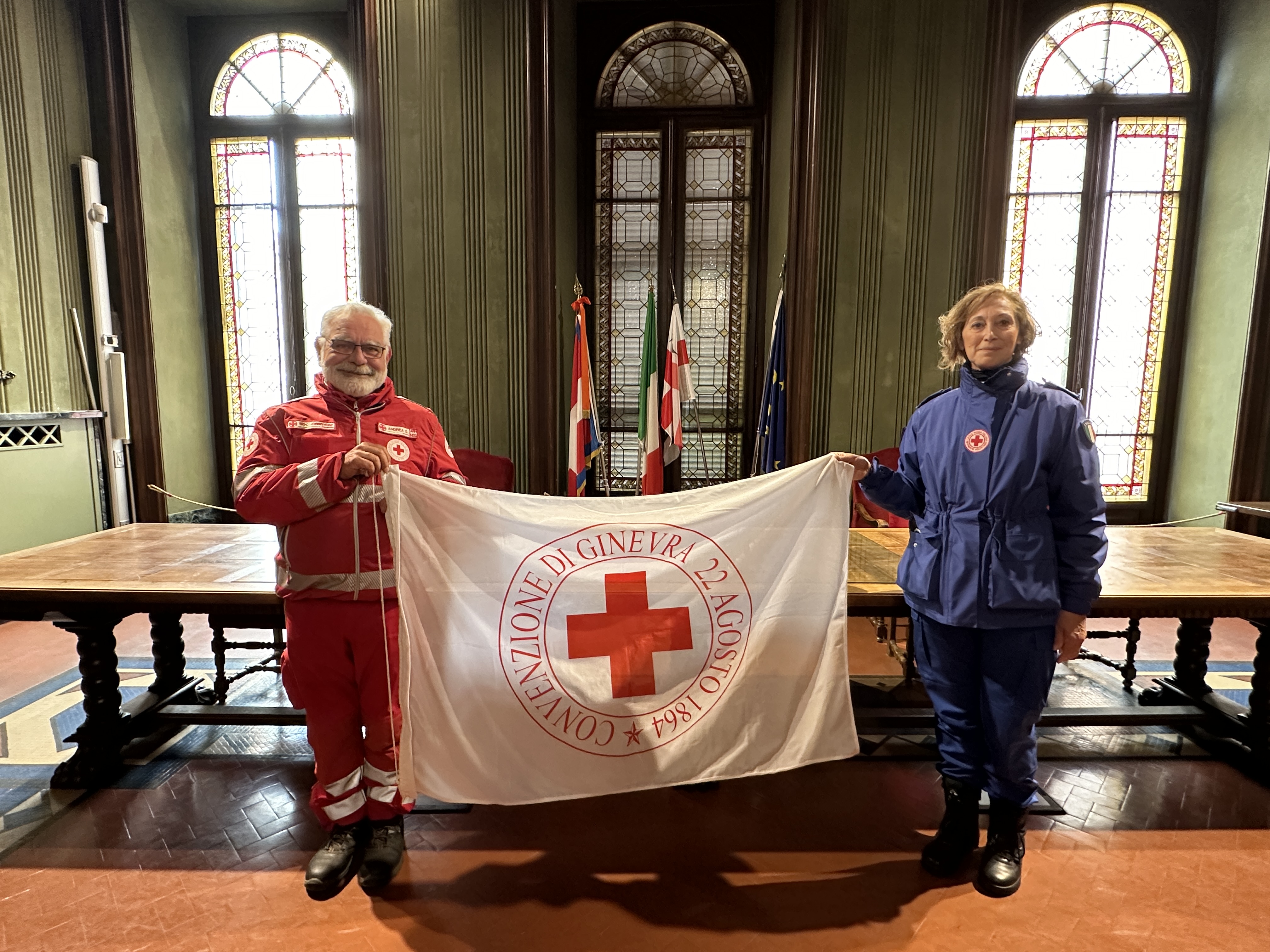 Torri illuminate di rosso e bandiera esposta per la Giornata mondiale della Croce Rossa